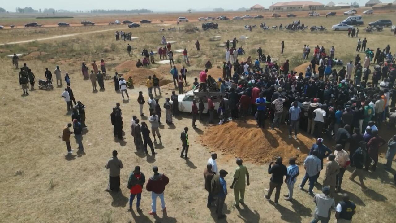 Families bury their close ones in a mass grave in the village of Maiyanga in Central Nigeria on December 27, 2023.