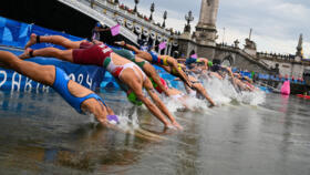 Athletes compete in the swimming race in the Seine during the women's individual triathlon at the 2024 Olympic Games in central Paris on July 31, 2024.