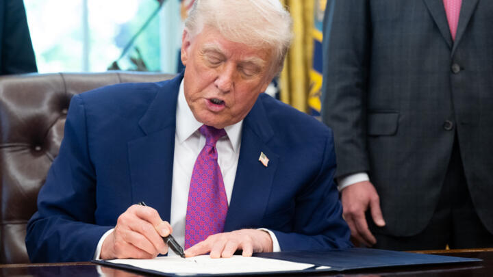 US President Donald Trump signs on legislation in the Oval Office of the White House in Washington, DC, on May 9, 2025. 