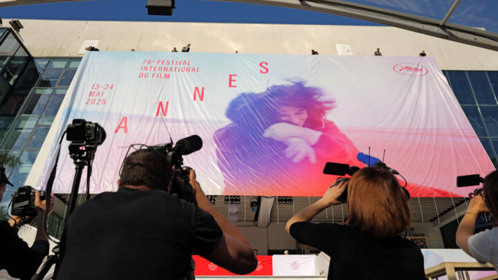 Workers install the official poster of the 78th Cannes Film Festival on the facade of the Palais des Festivals in Cannes, south-eastern France, on May 11, 2025.
