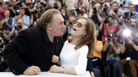 Actor Gerard Depardieu, left, tries to kiss actress Isabelle Huppert during a photo call for the film "Valley of Love", at the 68th Cannes Film Festival.