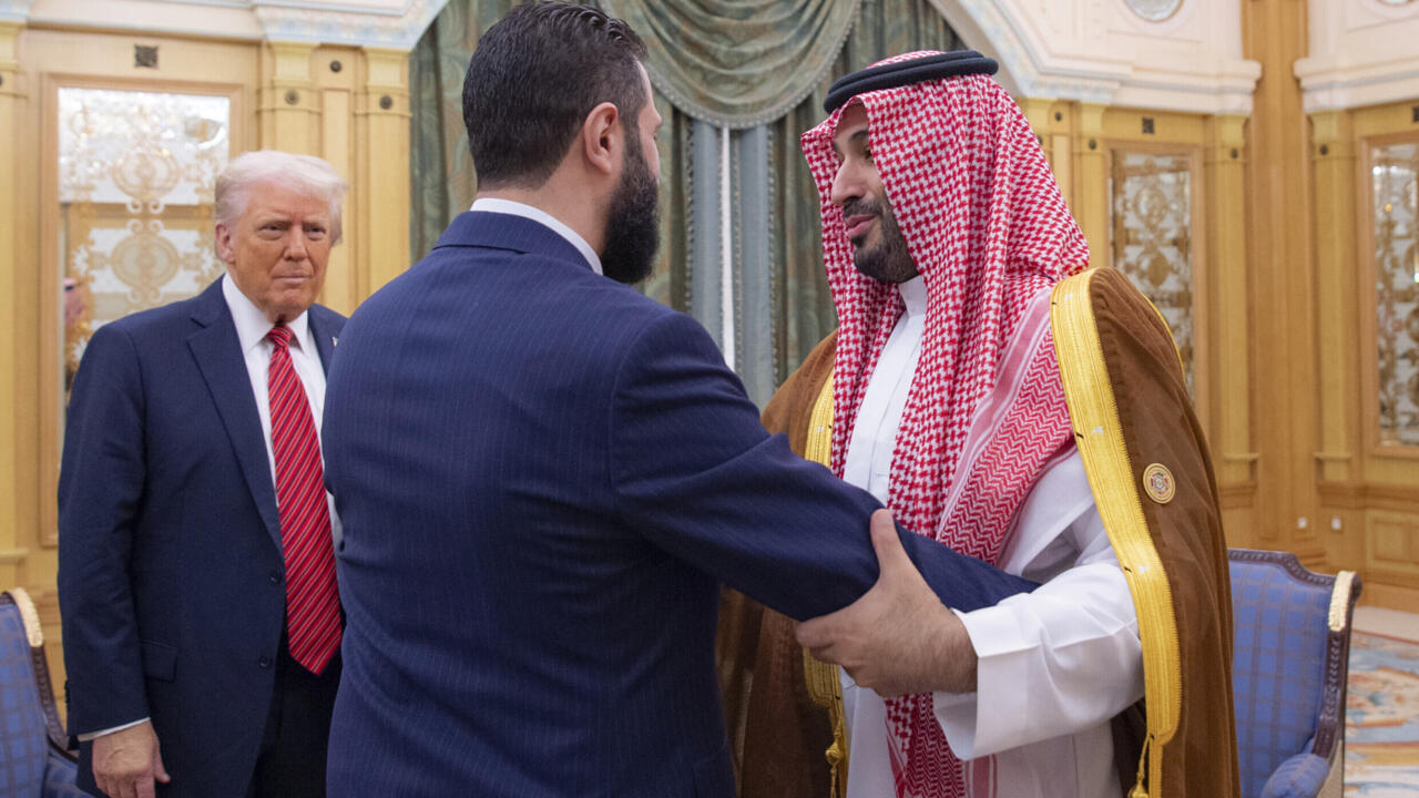 Le président Donald Trump regarde Mohammed ben Salmane saluer chaleureusement le président syrien par intérim Ahmed al-Charaa, le 14 mai 2025 à Riyad, en Arabie saoudite.