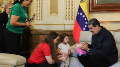 Handout picture released by Venezuela's presidency showing President Nicolas Maduro (R) with Yorelys Bernal (C) and her daughter Maikelys Espinoza after the girl's return from the United States, where she was kept after her parents' deportation