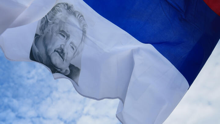 Un drapeau de la coalition Frente Amplio avec le visage de l'ancien président uruguayen Jose "Pepe" Mujica, photographié devant le Palais législatif à Montevideo, le 14 mai 2025.