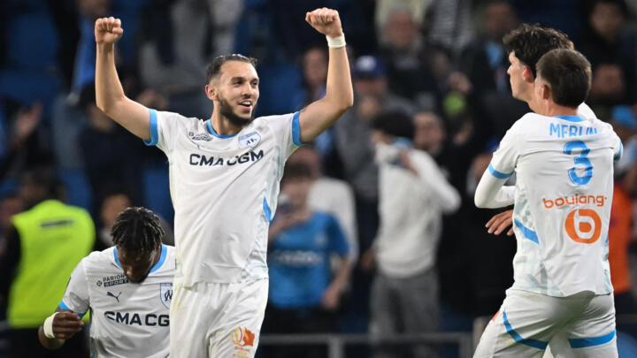Marseille's Algerian forward #09 Amine Gouiri (L) celebrates after scoring his team's third goal at the end of the French L1 football match between Le Havre AC and Olympique de Marseille (OM) at The Stade Oceane in Le Havre, north-western France, on May 10, 2025. Shortly after the hour mark and opening goal of Marseille, a brawl broke out in a corner adjacent to the Le Havre kop and spectators left the stand to take cover, bringing the match to a halt in the 64th minute and prompting referee Willy Delajod to send the players back to the dressing room.