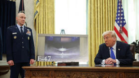 US President Donald Trump next to an image of an F-47 sixth-generation fighter jet is displayed with U.S. Chief of Staff David W. Allvin stands nearby, in the Oval Office on March 21, 2025.